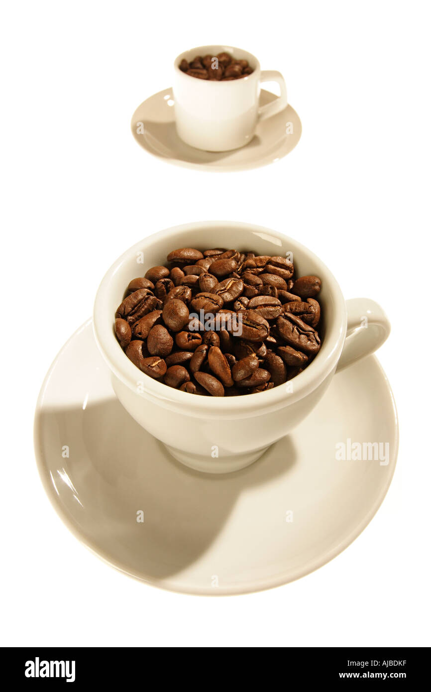 Zwei Tassen mit gerösteten Kaffeebohnen vor weißem Hintergrund Stockfoto
