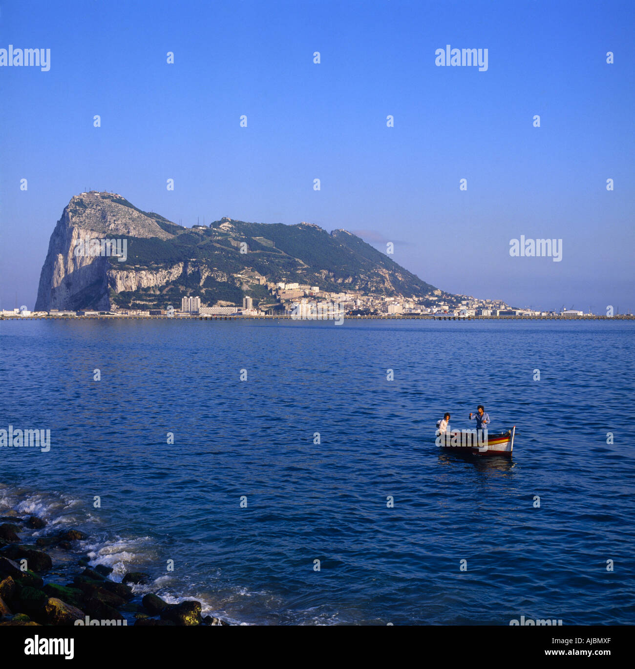 Blick auf das Meer mit zwei Männern in kleinen Boot der steilen Klippen Felsenstadt und Panorama von La Linea von Gibraltar Stockfoto