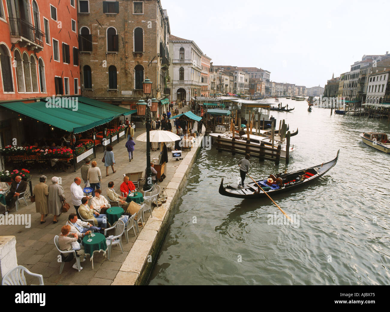 Am Ufer Café und Touristen mit Gondeln auf dem Canal Grande in Venedig Stockfoto