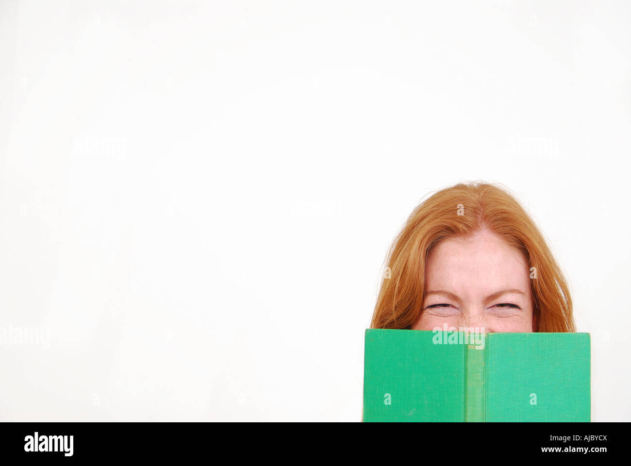 Porträt einer Frau versteckt sich hinter einem Buch Stockfoto