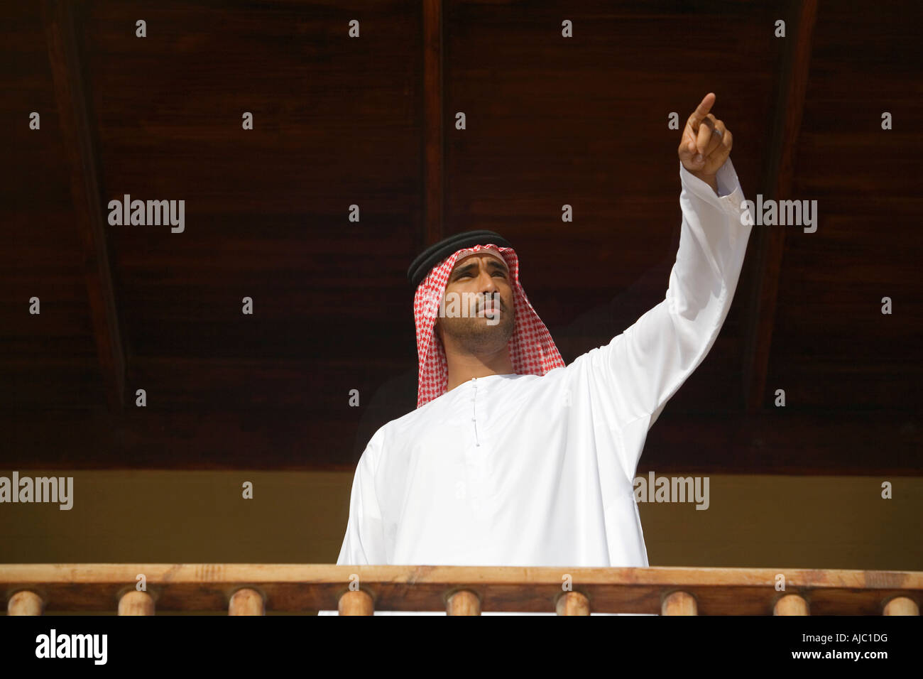 Arabische Mann winken auf einem Balkon, Low Angle View Stockfoto