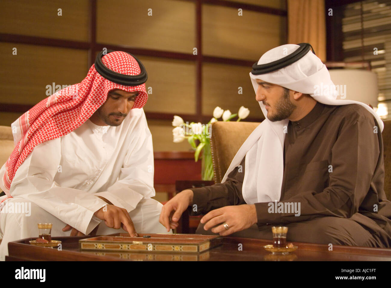 Zwei arabische Männer spielen Backgammon im Wohnzimmer Stockfoto