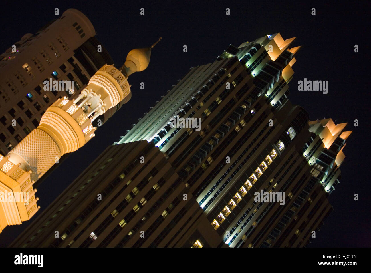 Beleuchtete Moschee vor Hochhäusern in der Nacht, diagonal view Stockfoto