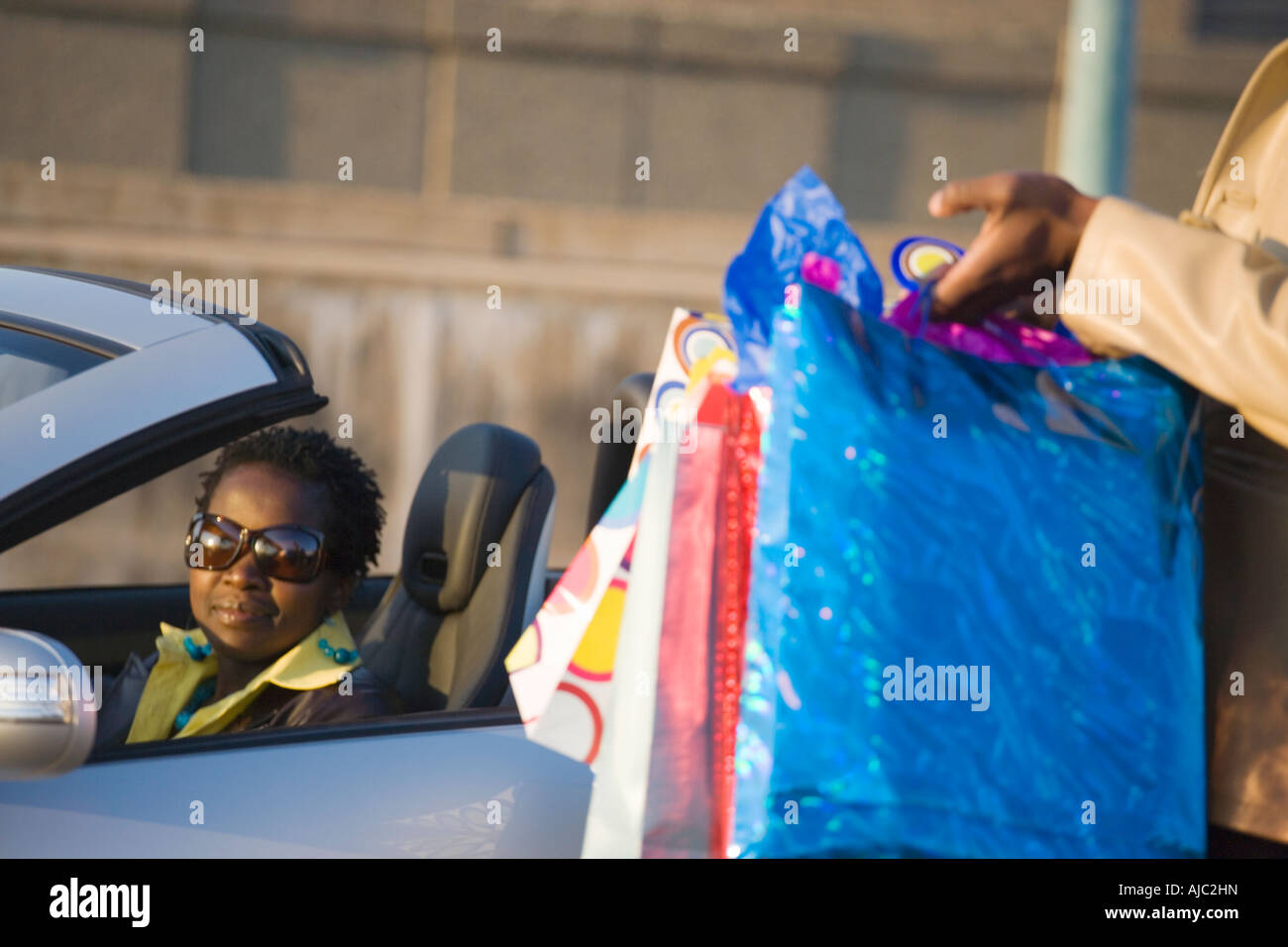 African Lady sitzen in Sportauto Stockfoto