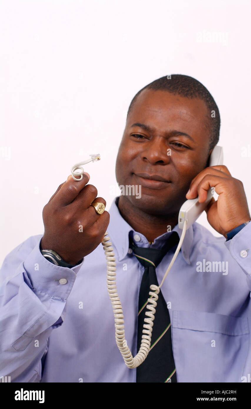 Junge afrikanische Mann hält eine defekte Telefonleitung Stockfoto