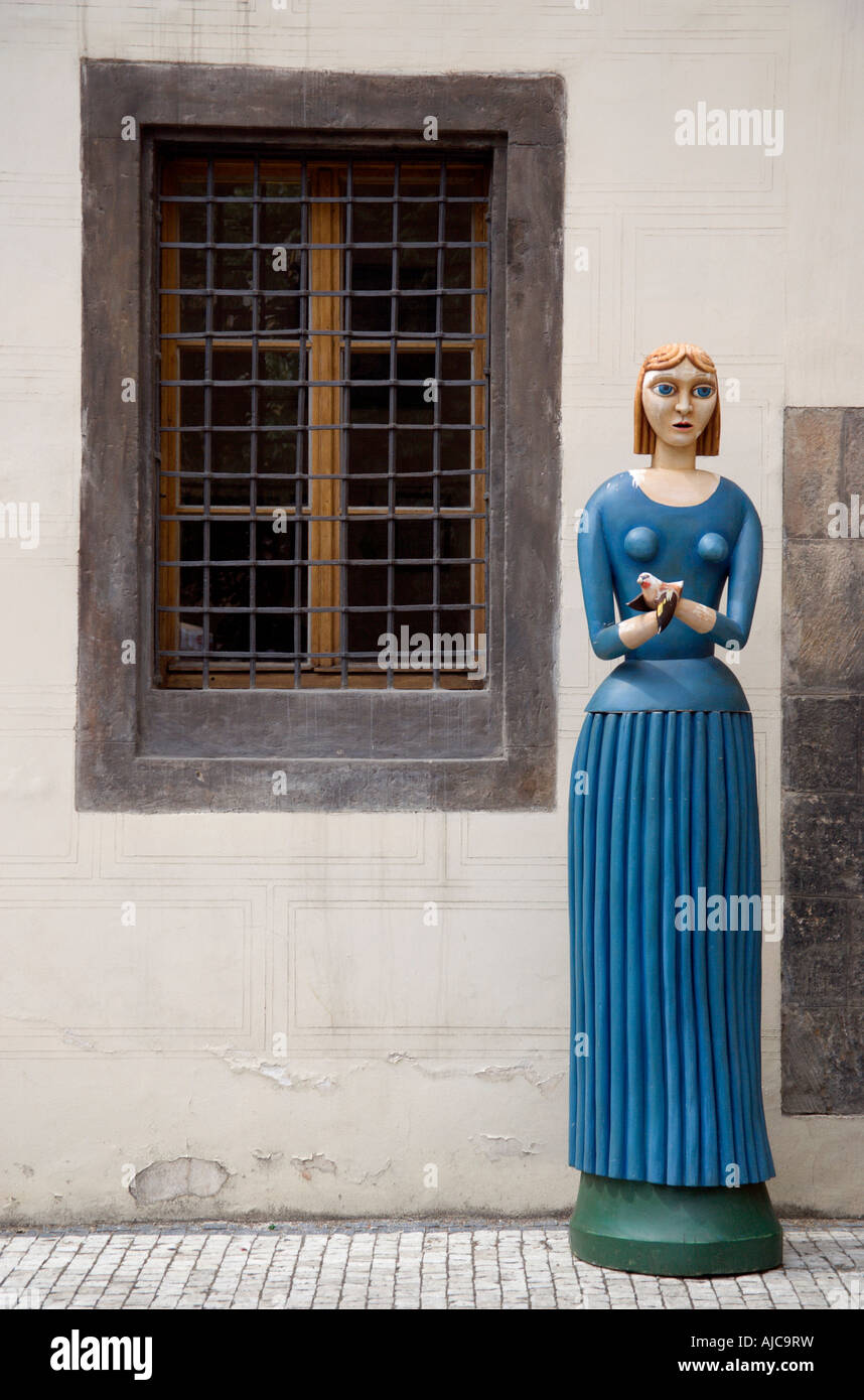 Tschechien Bohemia Prag A geschnitzt und bemalt Holzfigur einer Frau mit einem Vogel In beiden Händen stehend auf Bürgersteig Stockfoto