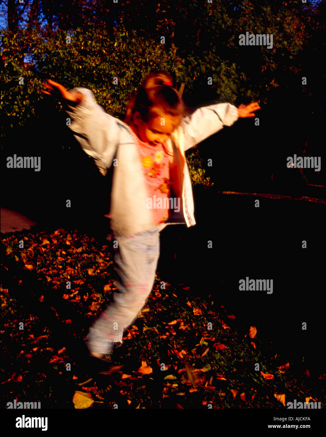 Kind spielt im Laub Stockfoto