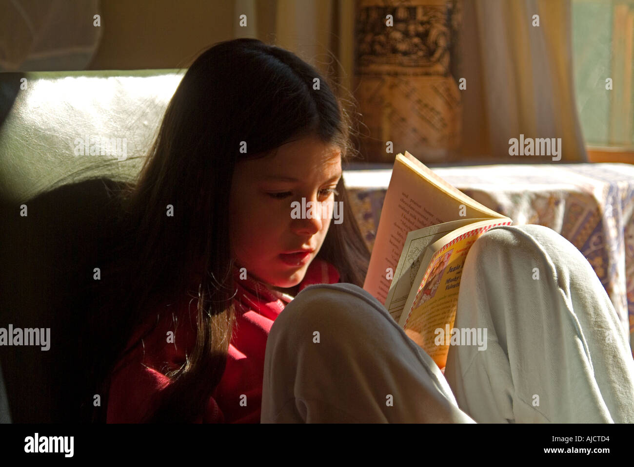 Ein 9 Jahre altes Mädchen mit großer Konzentration zu lesen Stockfoto