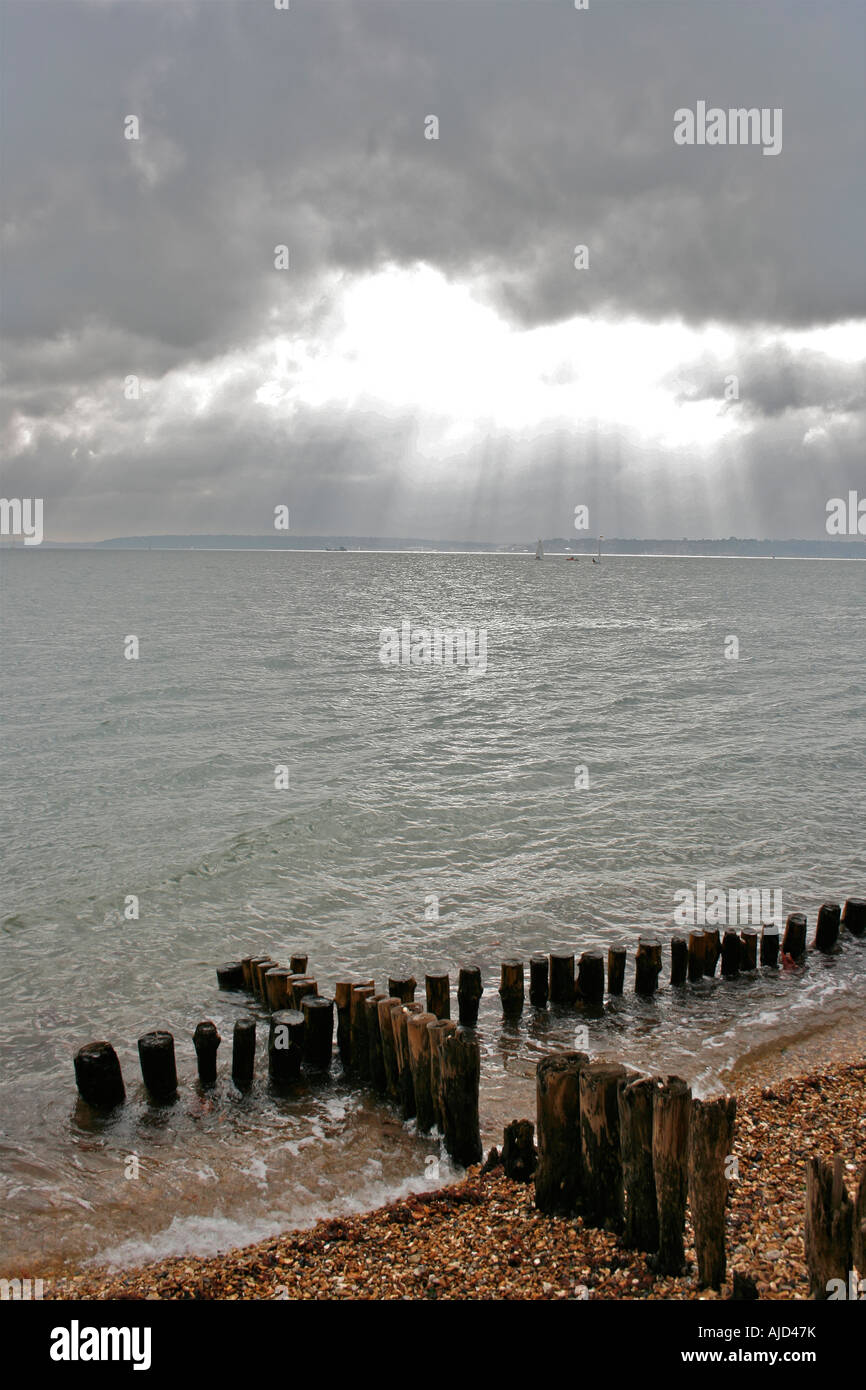 Southampton Water, einem hölzernen Buhne und Strand Kieselsteine Satz gegen eine imposante Himmel bei Calshot Spit, Calshot, Hampshire Stockfoto