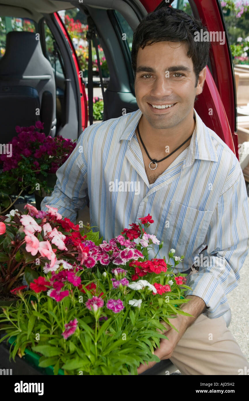 Mann laden Blumen in Rückseite des Van, Porträt Stockfoto