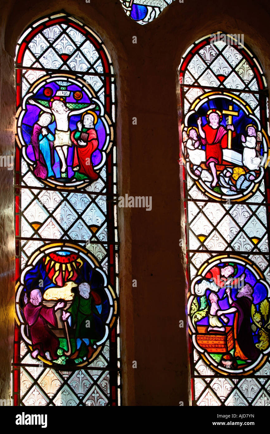 Hauptfenster mit zwei hellen Glasfenstern, die Abraham und Christus in der St Botolphs Church, Hardham, West Sussex darstellen. Stockfoto