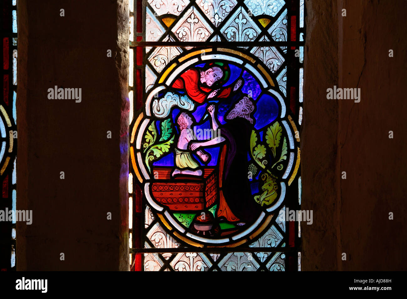 Glasfenster mit der Darstellung von Abraham, der seinen Sohn Isaac als Opfer für Gott in der St Botolphs Church in Hardham, West Sussex, aufopferte. Stockfoto