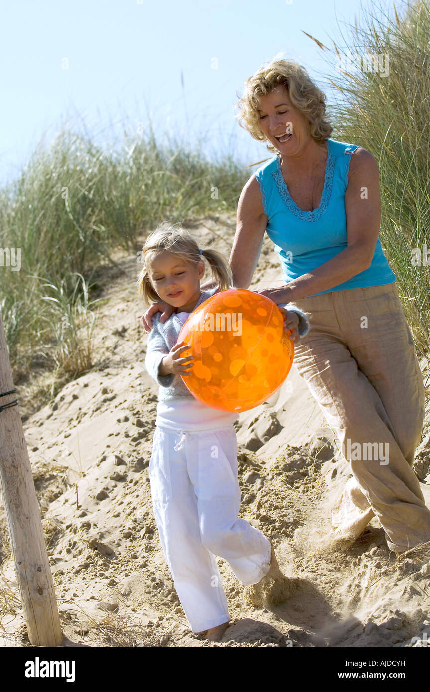 Großmutter und Mädchen spielen mit Ball am Strand Stockfoto