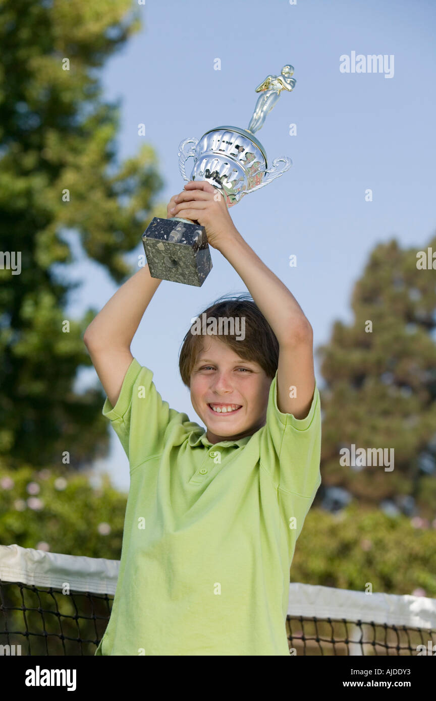 Junge auf Tennis court Tennis Trophy hält Porträt Stockfoto