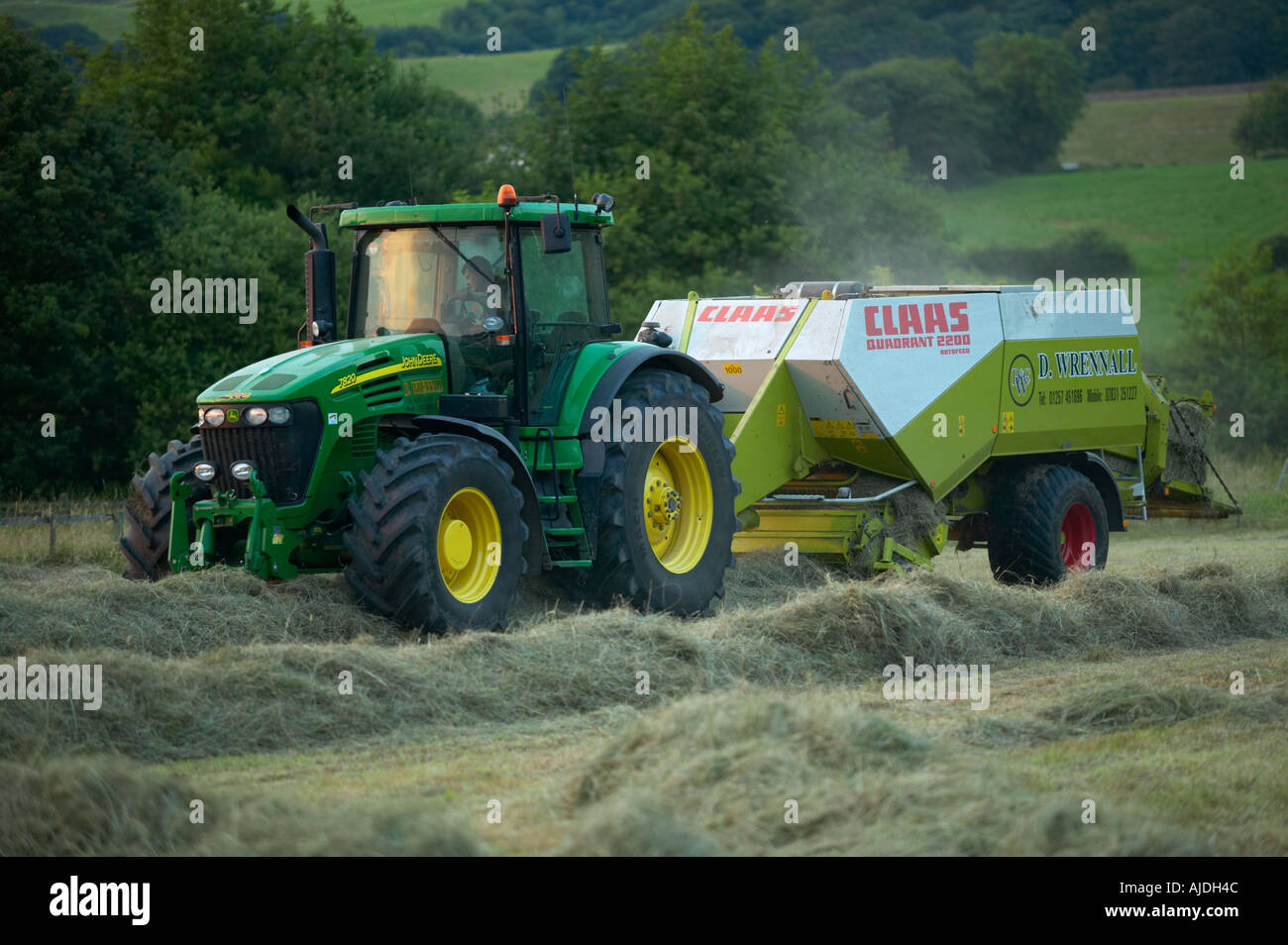 Bauern Heuernte im Sommer mit Traktor und Pressen Stockfoto