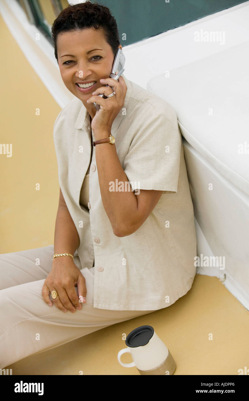 Frau sitzt auf Yacht, telefonieren mit Handy, (Hochformat), (erhöhte Ansicht) Stockfoto