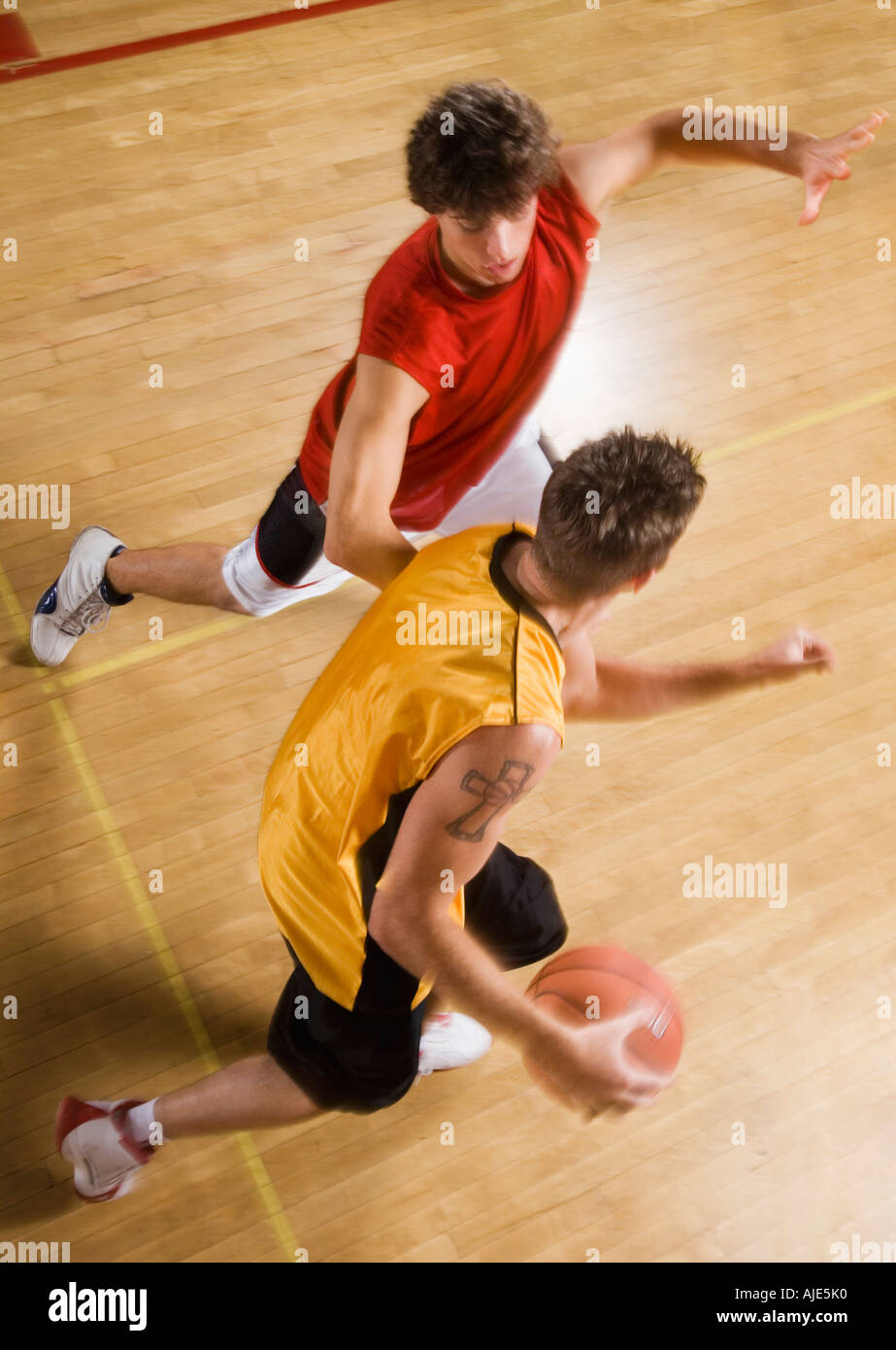 Zwei junge Männer spielen Basketball auf Hallenplatz Stockfoto