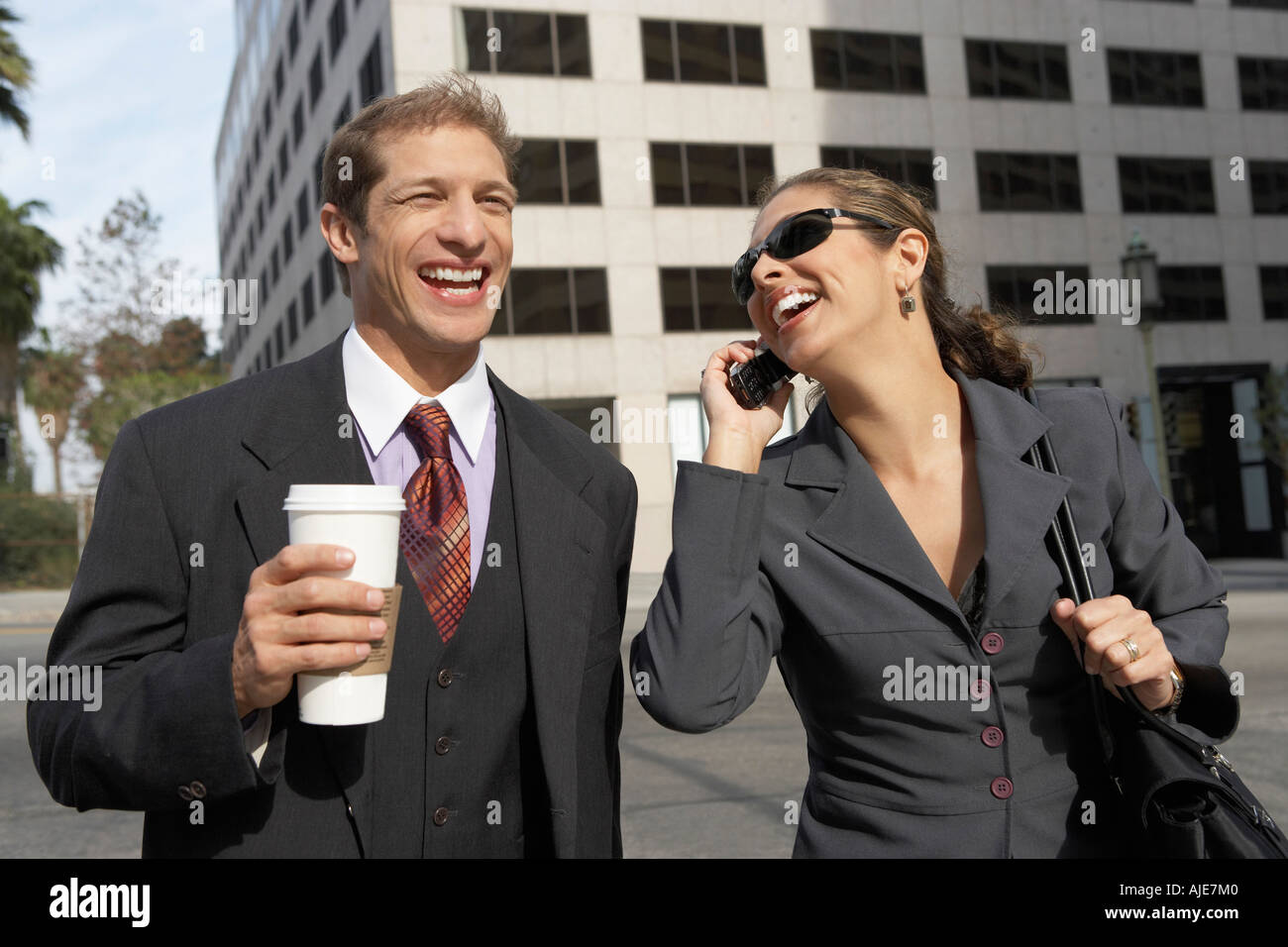 Geschäftsmann mit Kaffee neben Business-Frau mit Handy auf Stadtstraße Stockfoto