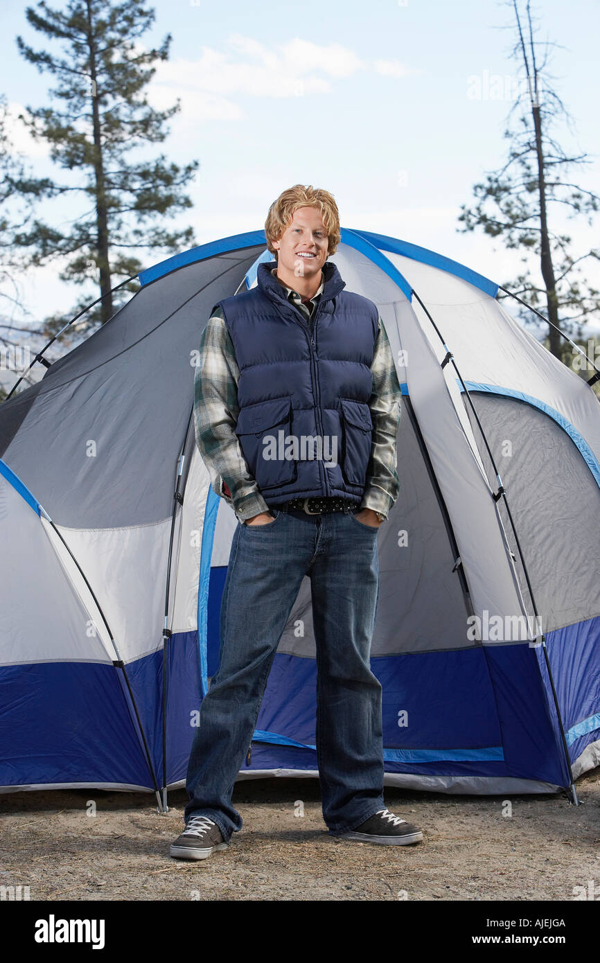 Young Man in warme Kleidung vor Zelt stehen. Stockfoto