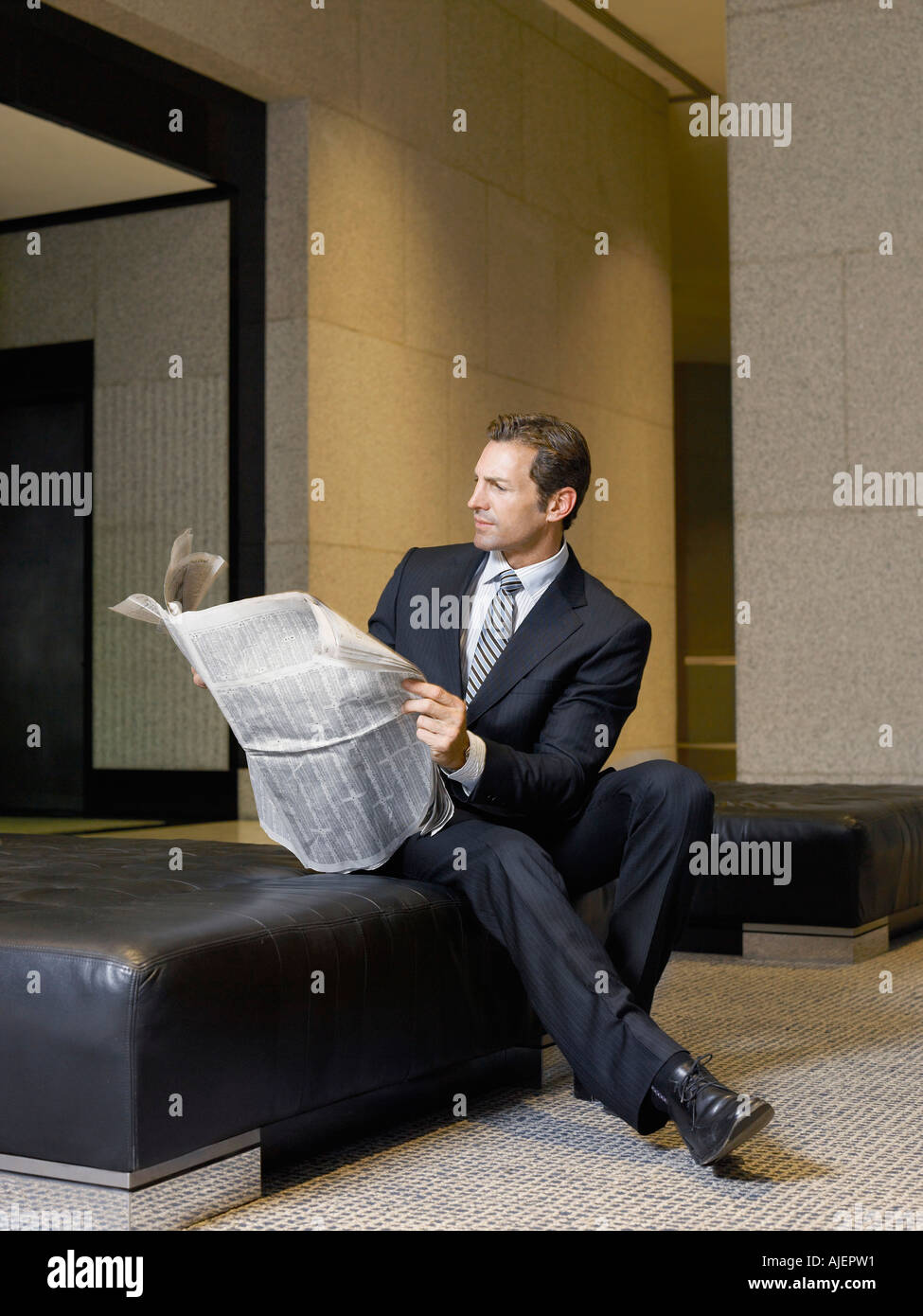 Geschäftsmann lesen Zeitung in der lobby Stockfoto