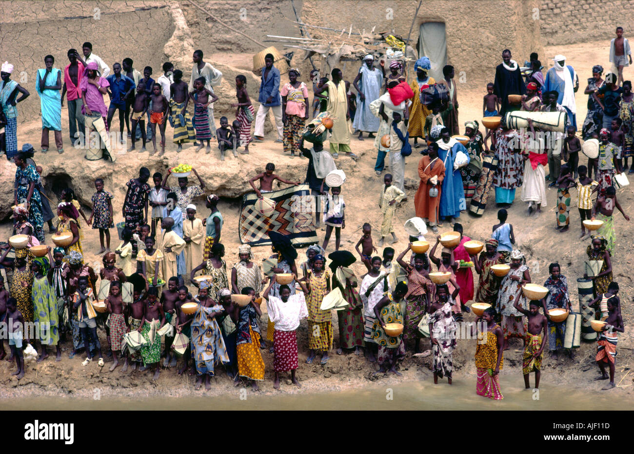 Stadt Diafarabe am Fluss Niger, Mali. Händler verkaufen Obst, Milch und gewebte Matten an Käufer bei der Annäherung an Passagier-Fähre Stockfoto