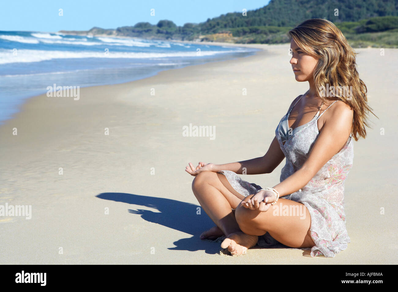 Junge Frau am Strand, Seitenansicht meditieren Stockfoto
