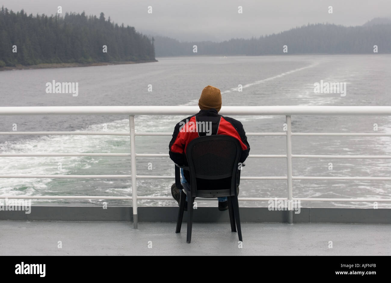 Ein Passagier auf einem Schiff aus dem Alaska Marine Highway Ferry System auf dem Achterdeck als das Schiff läuft in der innen-Resümee Stockfoto