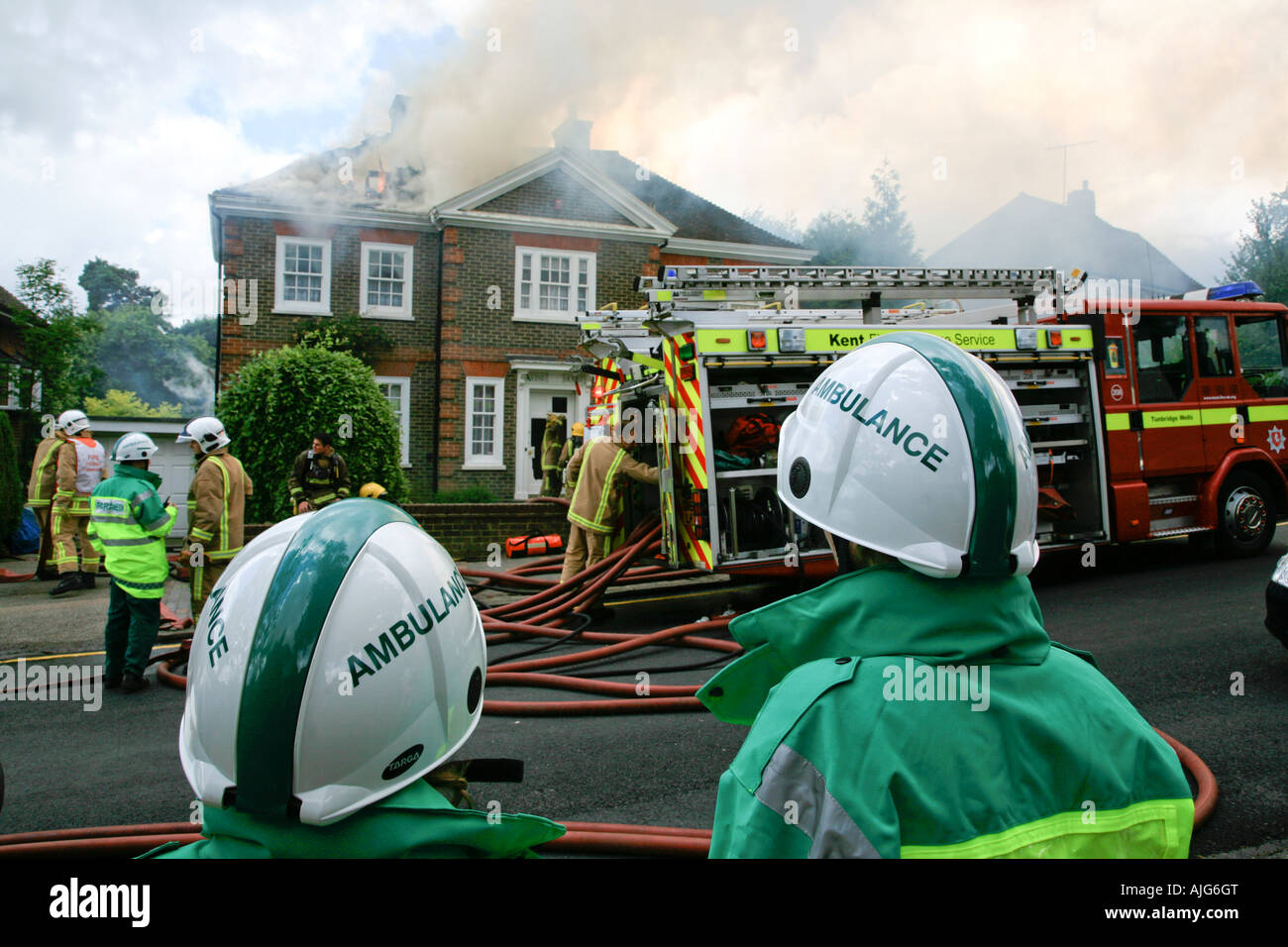 Schüler und Krankenwagen Männer beobachten Feuerwehr Feuerwehr und eine Housefire in Tunbridge Wells Kent England vereint Ki Außerbetriebnahme Stockfoto