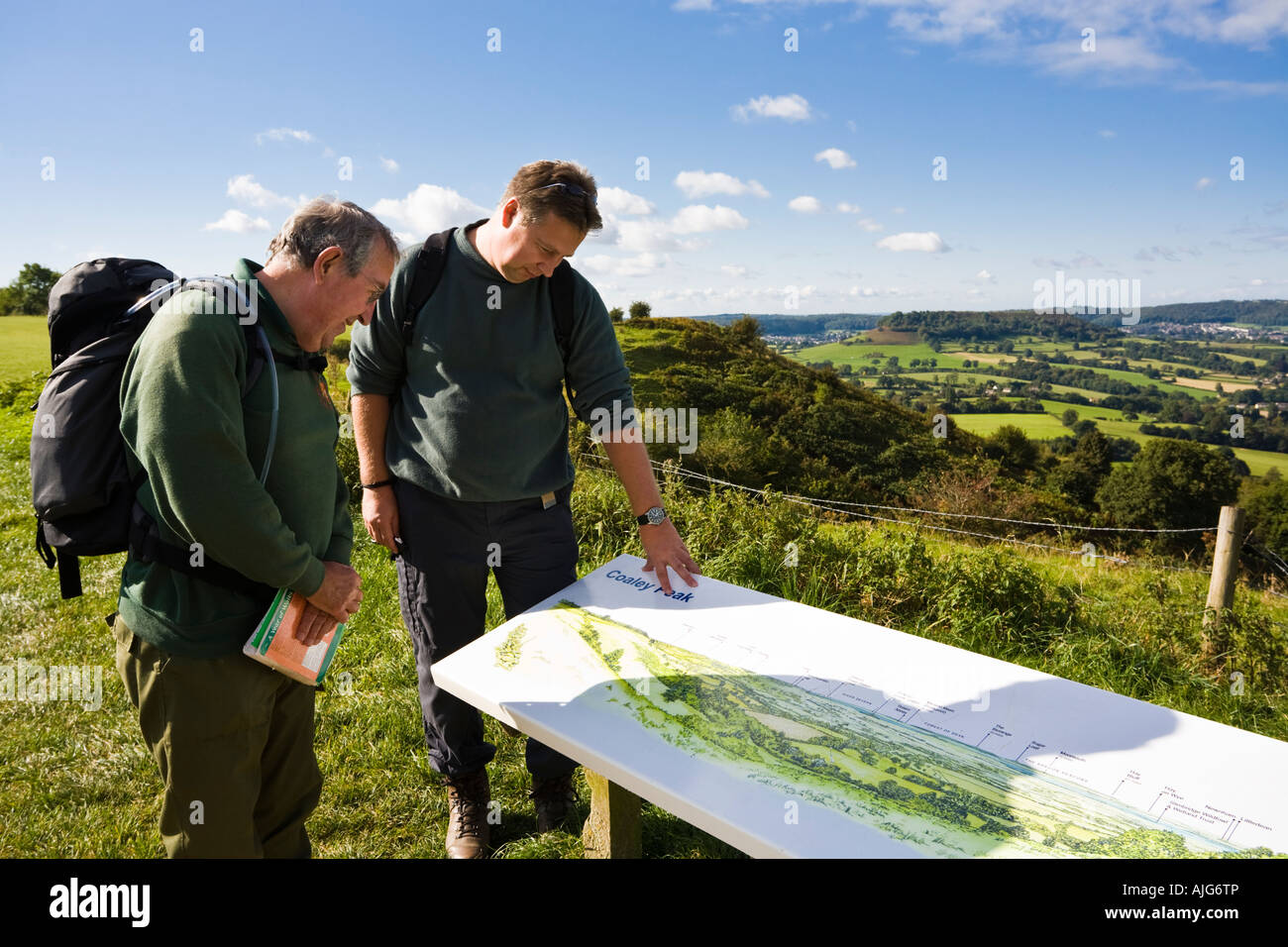 Zwei Wanderer unterwegs genießen den Blick über den Severn Vale aus Coaley Peak Picknick Website Gloucestershire Cotswold Stockfoto