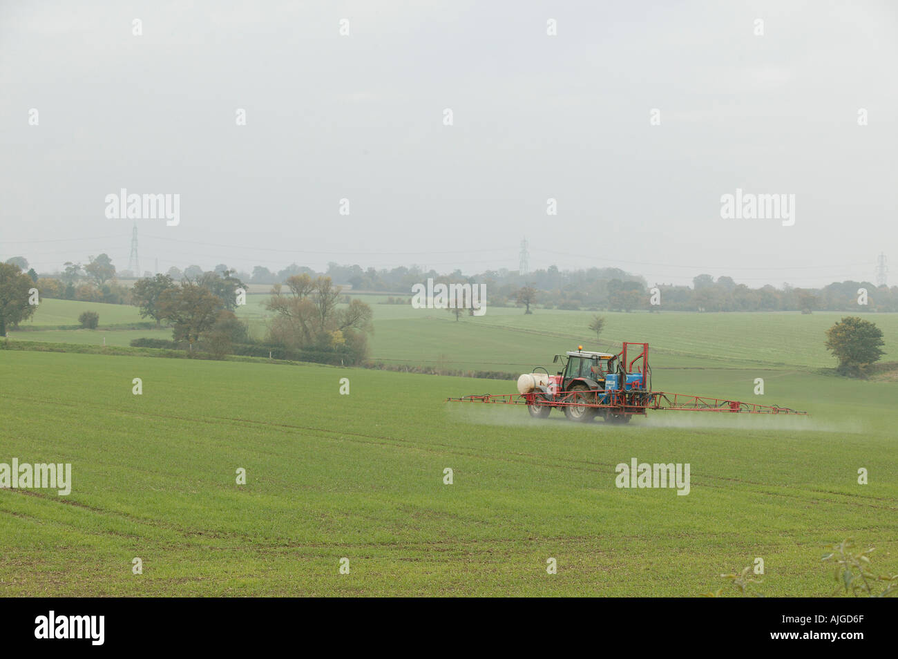 Landwirt Besprühen von Pflanzen mit Chemikalien in der britischen Landschaft Stockfoto
