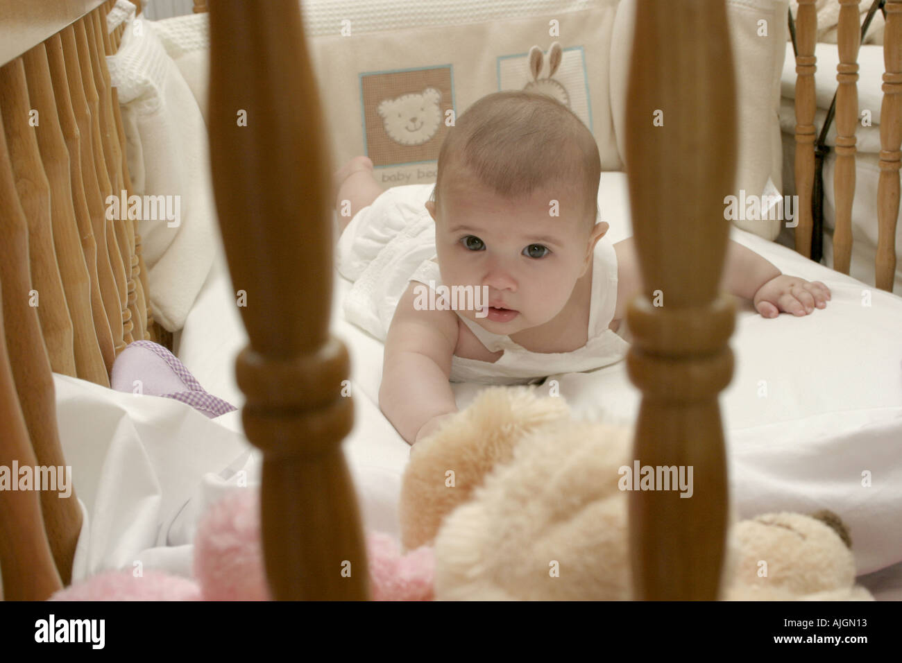 Babymädchen auf Bauch im Kinderbett Stockfoto