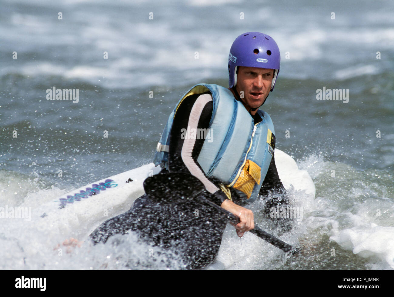 Junger Mann in Ocean Kayak Yak Brett im Surf auf Ocracoke Island, North Carolina, NC Stockfoto