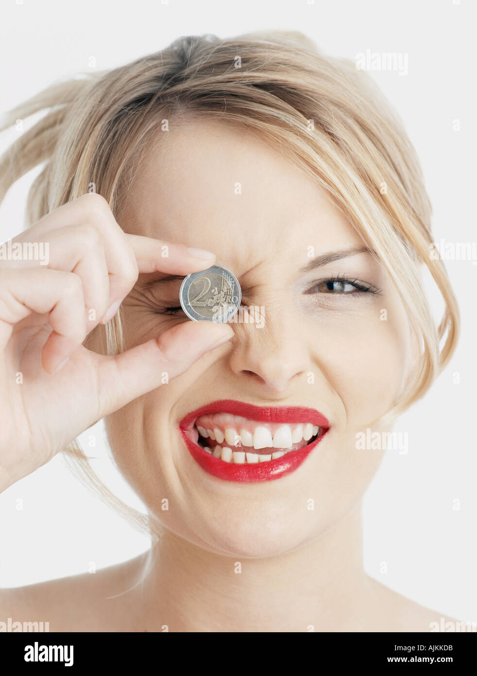 Frau mit Euro-Münze für ihr Auge Stockfoto