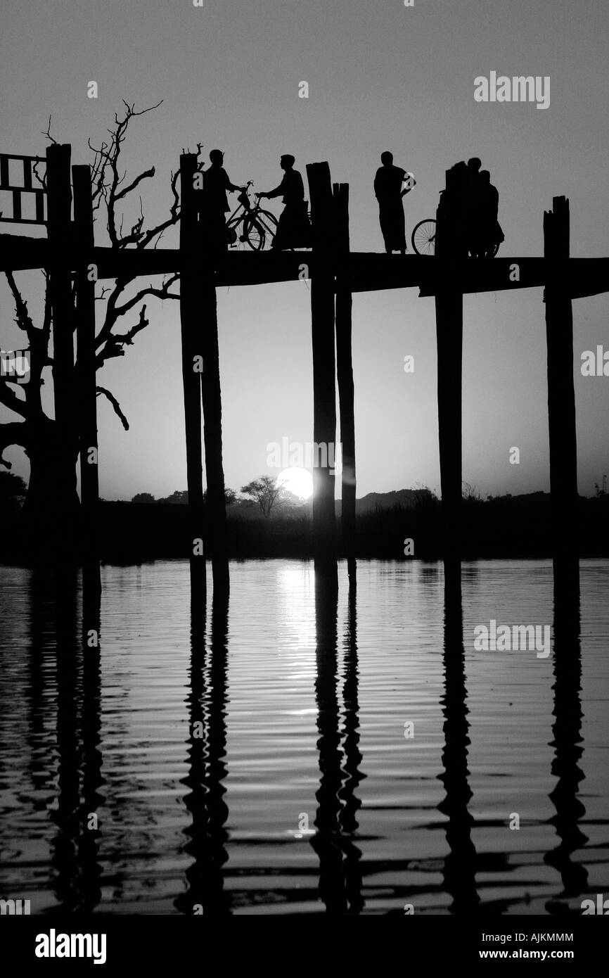 Birmanischen Menschen Kreuzung U Bein Brücke bei Sonnenuntergang, Amarapura, in der Nähe von Mandalay, Birma (Myanmar) Stockfoto