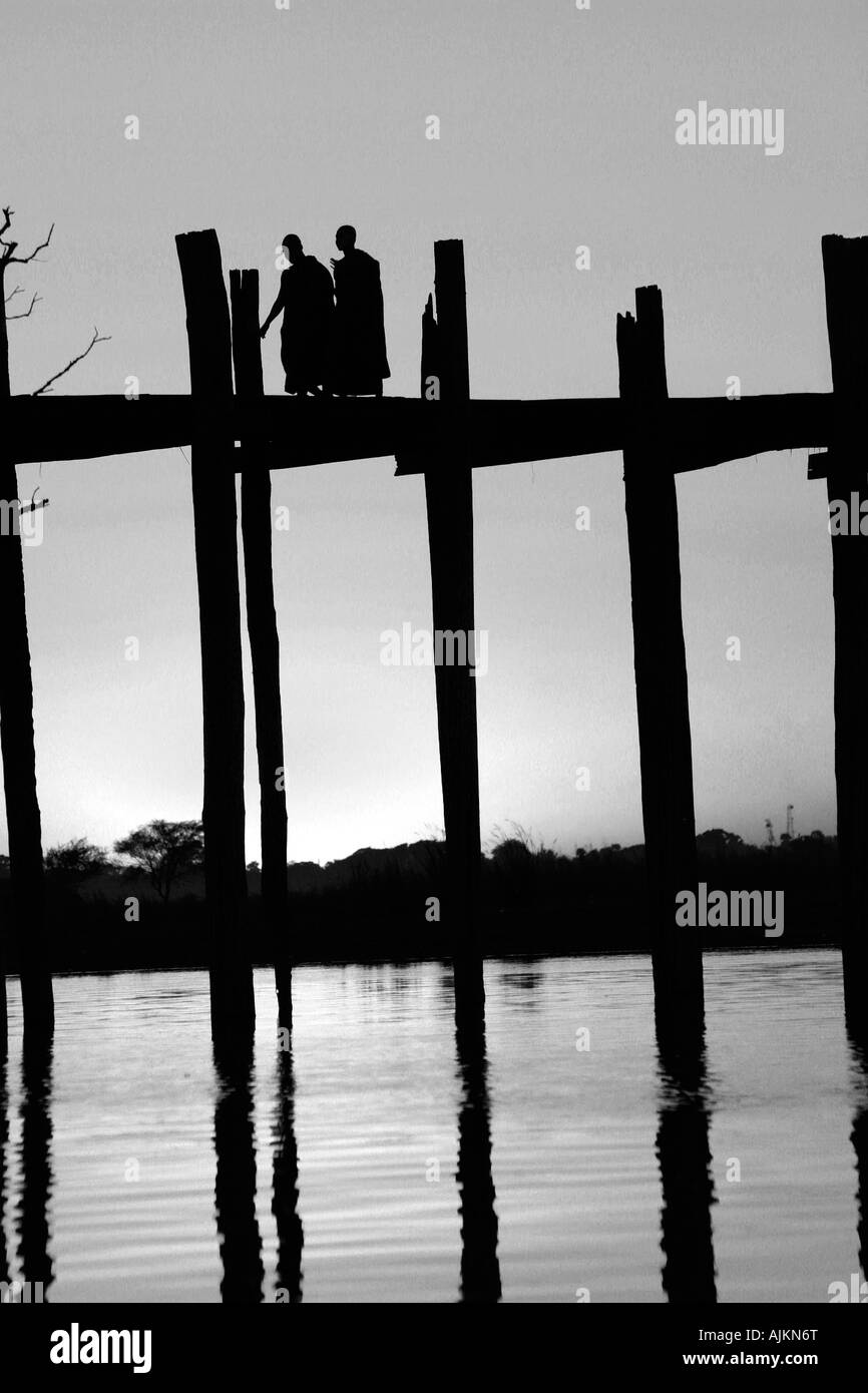 Buddhistische Mönche U Bein Brücke bei Sonnenuntergang, Amarapura, in der Nähe von Mandalay, Birma (Myanmar) Stockfoto