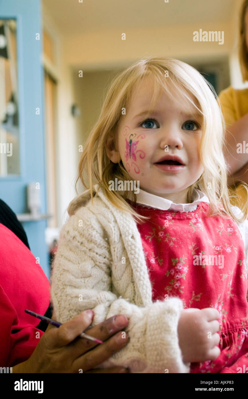 kleines Mädchen mit Schmetterling Gesicht malen Stockfoto