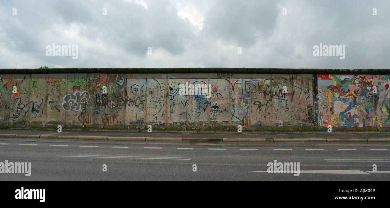 Abschnitt der Berliner Mauer an der Ostseite bei bewölktem Himmel gemalt, an einem regnerischen Tag Stockfoto