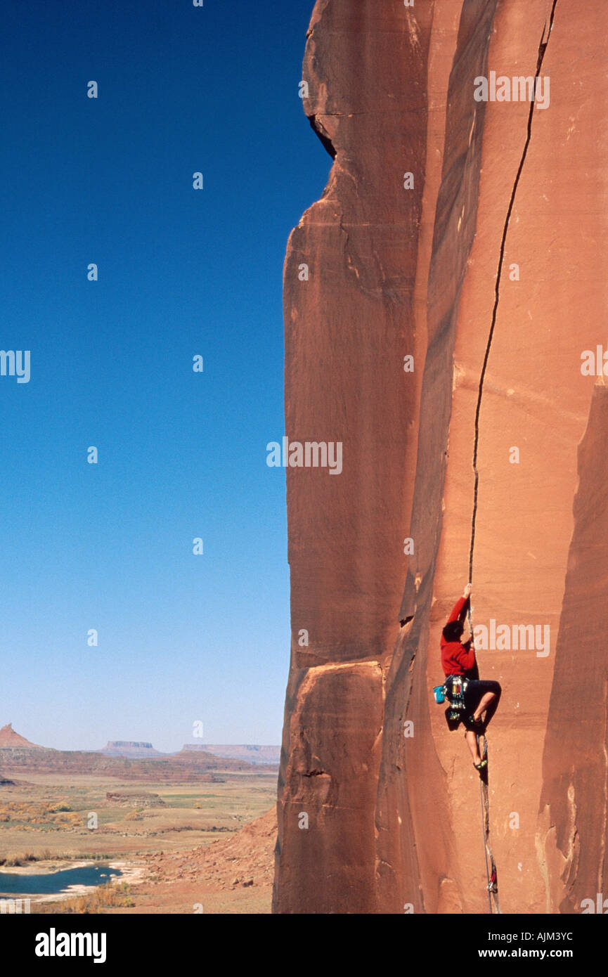 Kletterer Klettern dünnen Riss auf vertikale rote Klippe Stockfoto