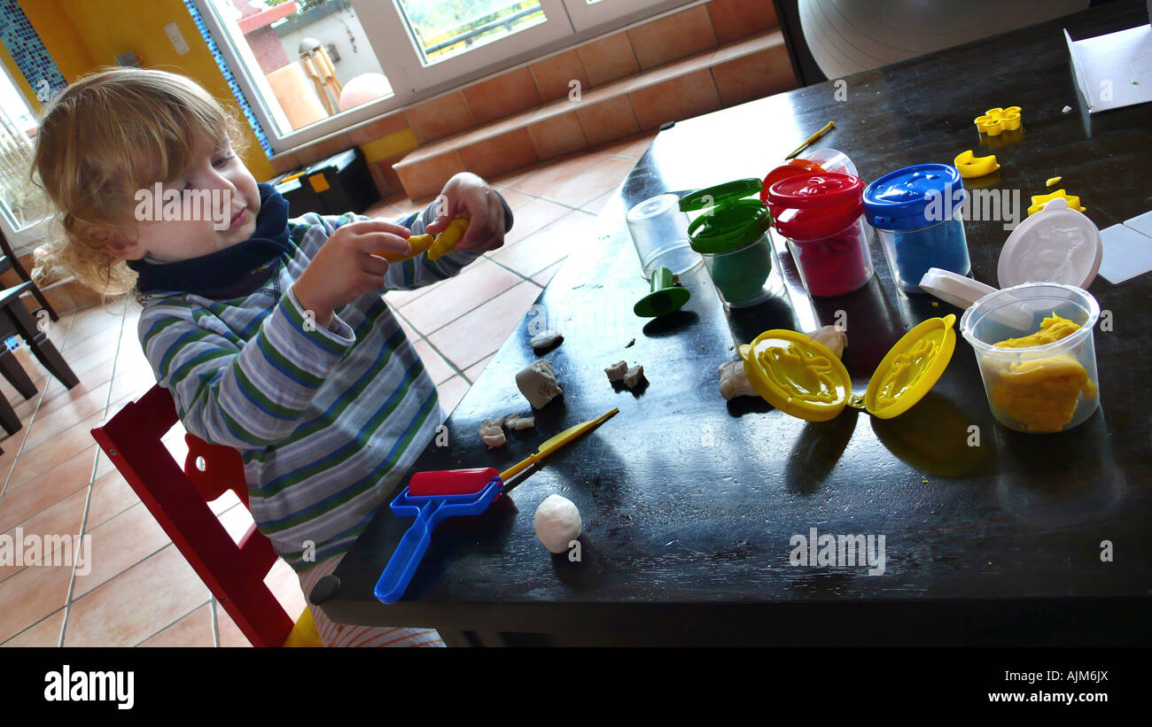 kleiner Junge spielt mit Knetmasse Stockfoto