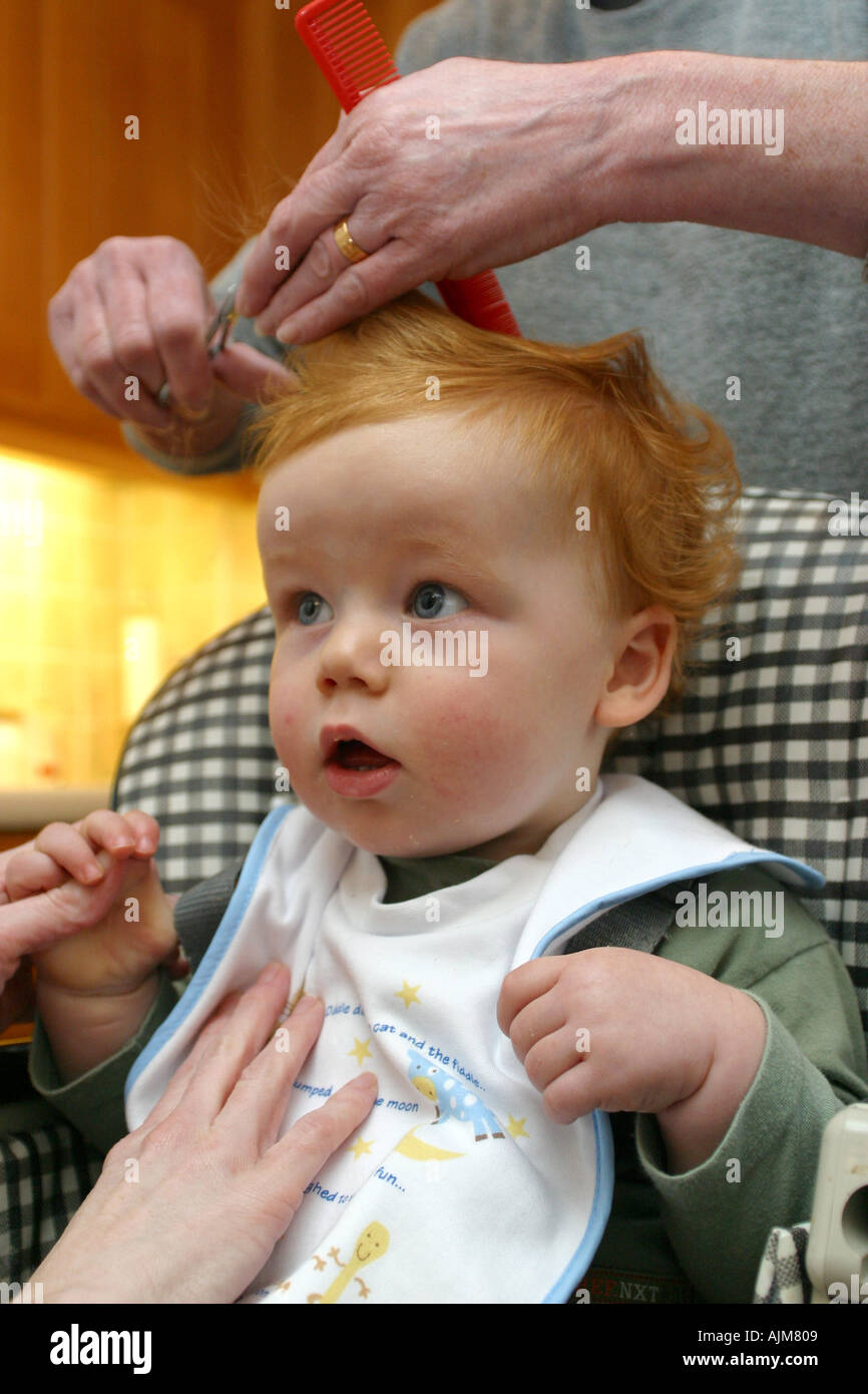 Ein Baby Mit Seiner Ersten Haarschnitt Im Alter Von 1 1 Jahr Alt Zuruckhaltend Sein Baby In Einen Hochstuhl Stockfotografie Alamy