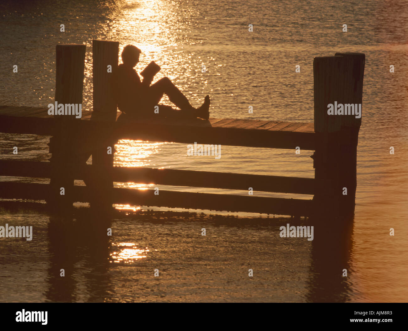 Person auf einem Pier lesen Stockfoto