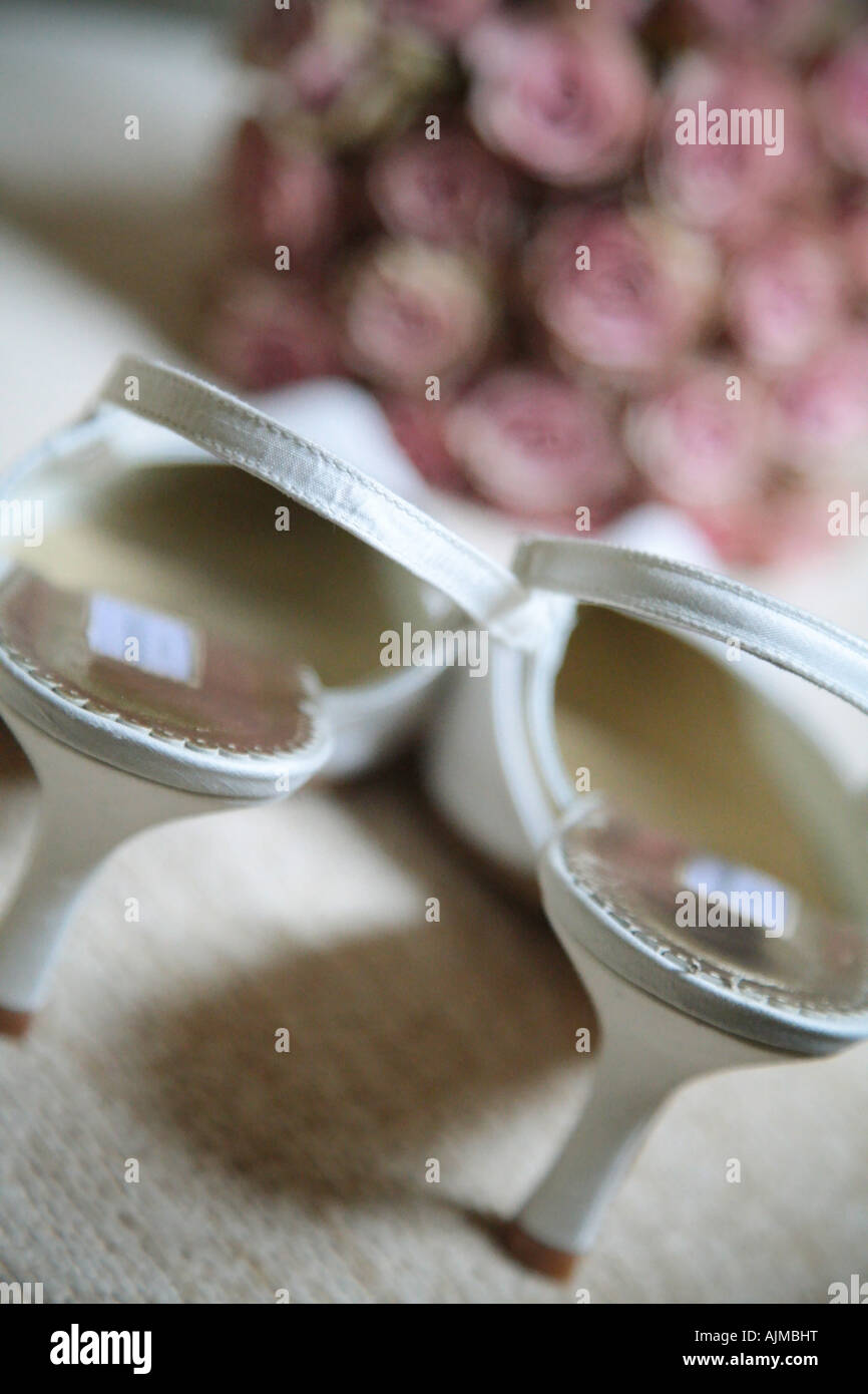weiße Hochzeitsschuhe und Blumen Stockfoto