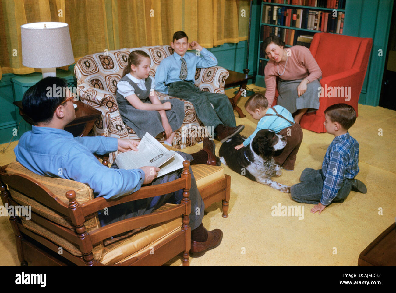 Familie entspannend im Wohnzimmer der 1950er Jahre Stockfoto