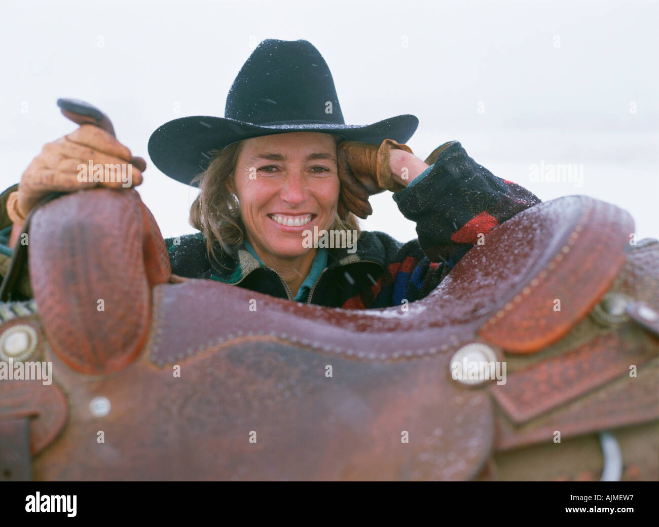Frau in Cowboy-Hut Sättel auf ihrem Pferd Stockfoto