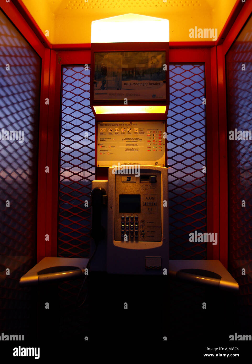 Telefonzelle in der Nacht mit Powelines im Hintergrund symbolisiert Kommunikation und Verbindungen Stockfoto