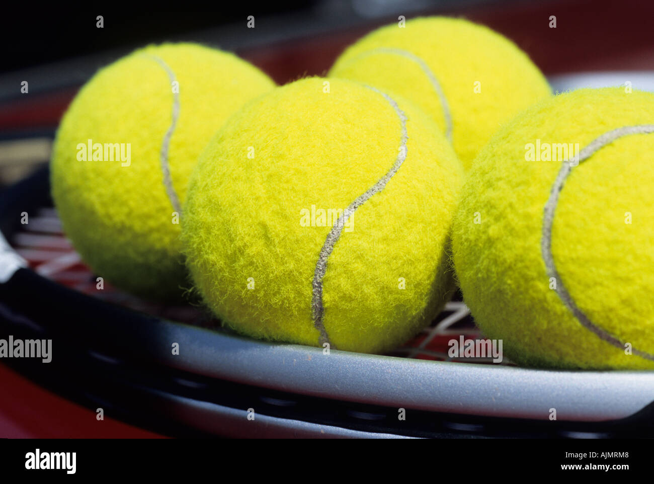 vier Tennisbälle platziert auf einem Tennisschläger Stockfoto