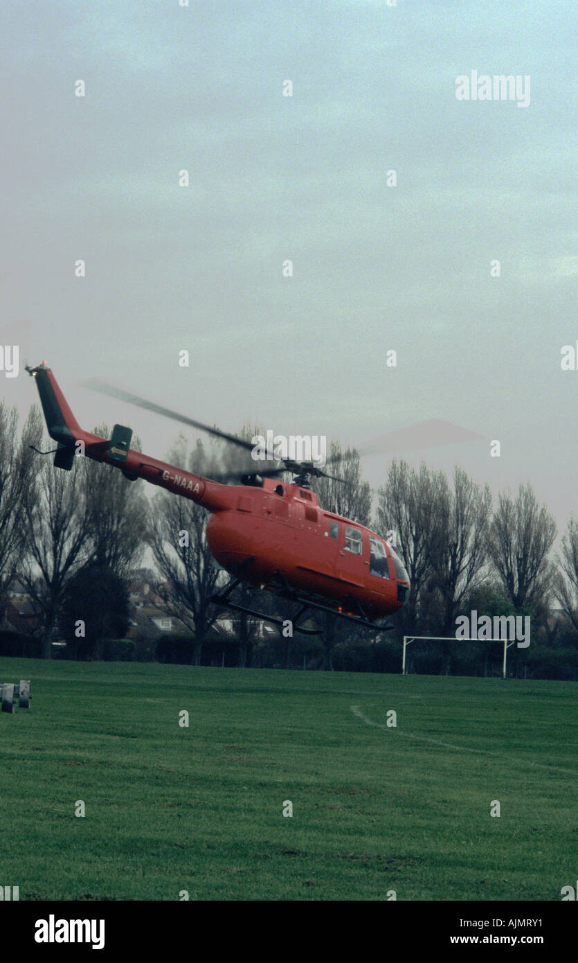 Luft Rettungshubschrauber ausziehen aus Fußballplatz nach Abholung eine verletzte person Stockfoto