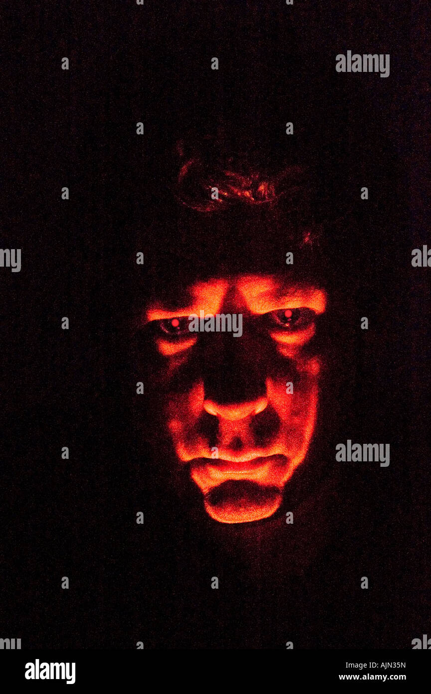 Mann mittleren Alters, beleuchtet von Fackel gruselige Halloween gespenstische Wirkung in der Nacht mit roten Augen Stockfoto