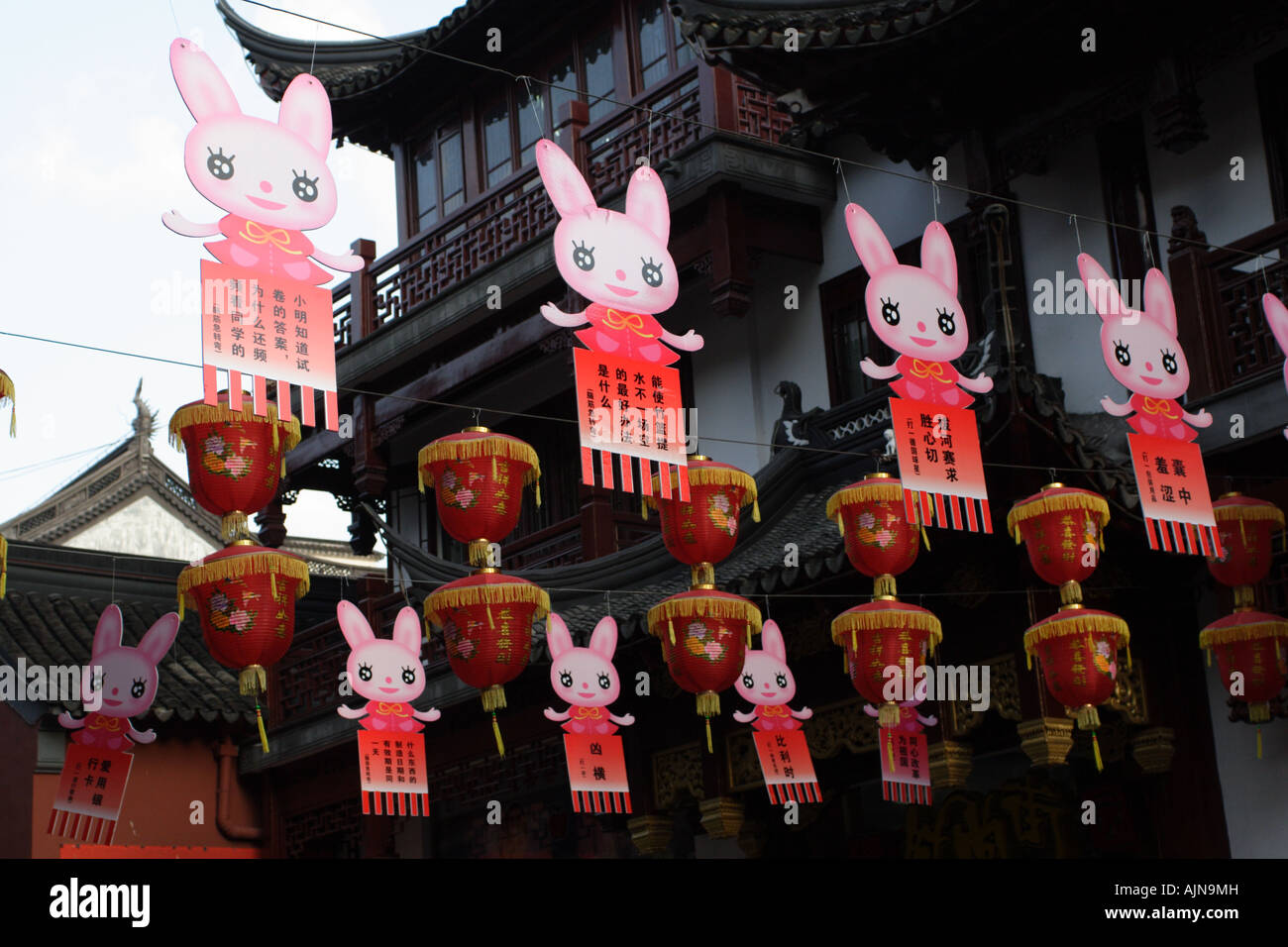 Laternen und Comic-Figuren in einer Straße in Shanghai hängen. Stockfoto