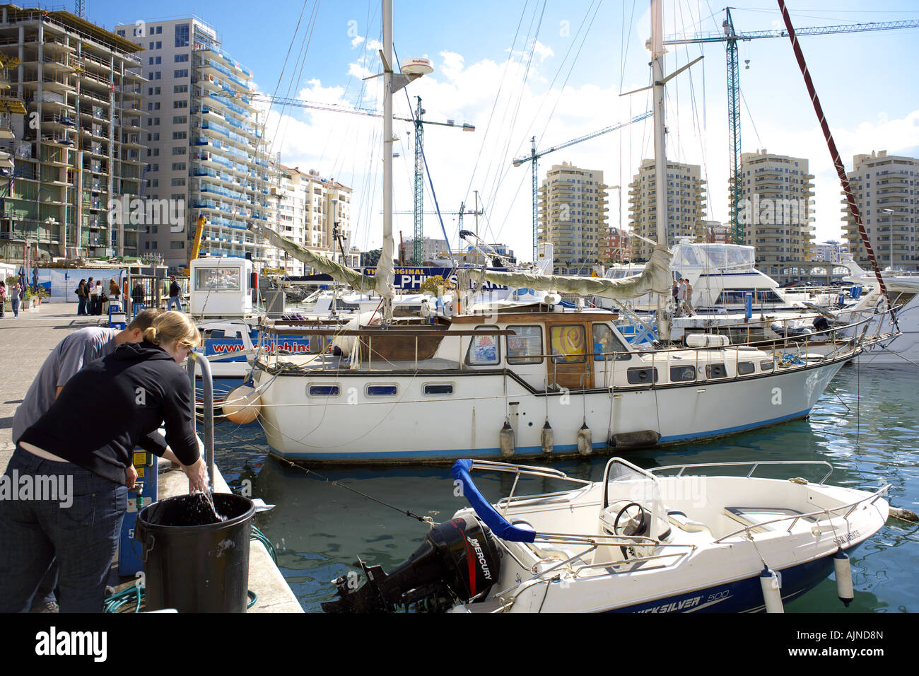 Mann und Frau Händewaschen in Eimer mit Wasser, Marina Bay, Gibraltar Stockfoto